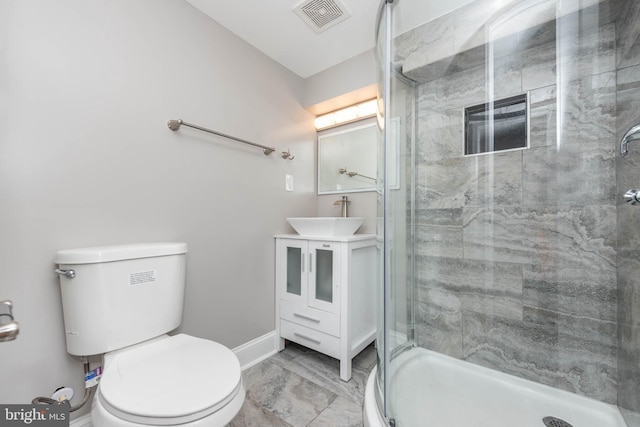 bathroom featuring vanity, a shower with shower door, and toilet