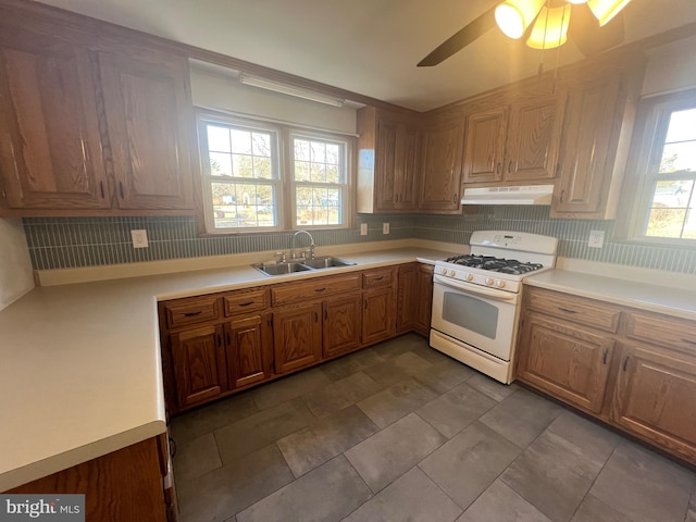 kitchen featuring gas range gas stove, sink, and ceiling fan