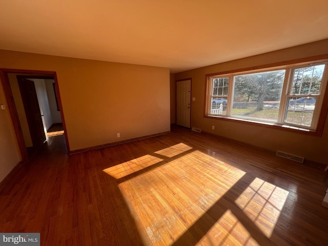 empty room with dark hardwood / wood-style flooring