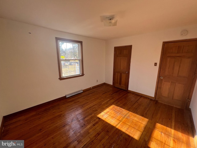 unfurnished bedroom with dark hardwood / wood-style flooring