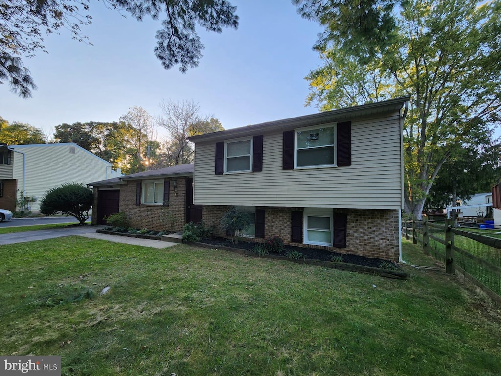 tri-level home with a garage and a front lawn