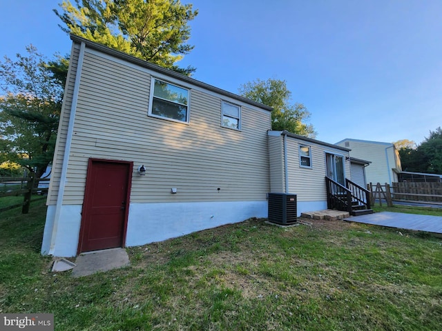 back of house with a yard and central air condition unit