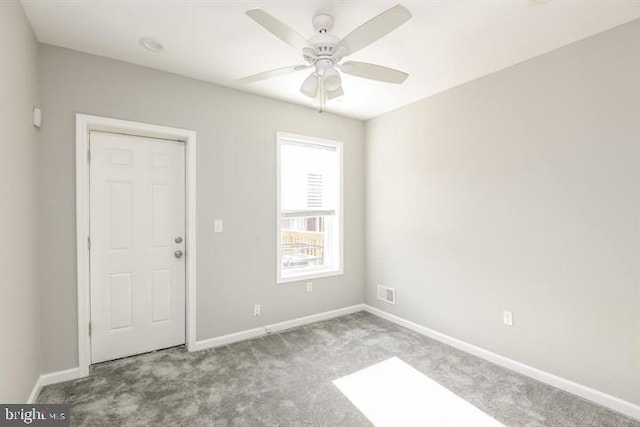 carpeted spare room with ceiling fan