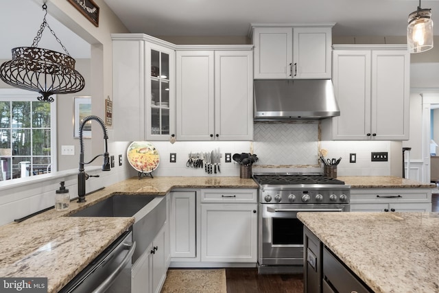 kitchen featuring appliances with stainless steel finishes, decorative light fixtures, light stone countertops, and white cabinets