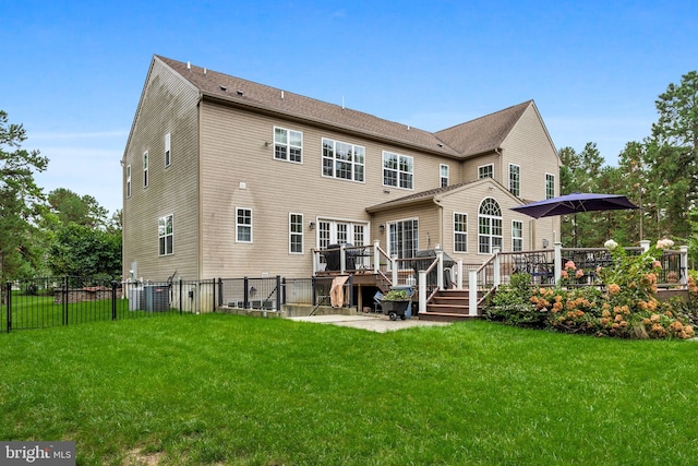 rear view of property featuring a deck and a lawn