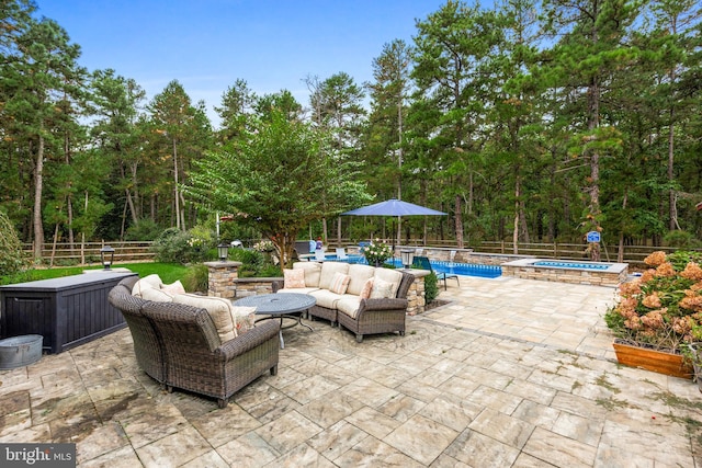 view of patio featuring an outdoor living space and a pool with hot tub