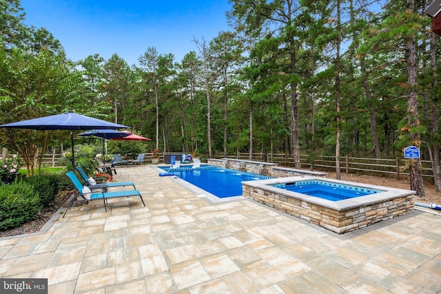 view of swimming pool with an in ground hot tub, pool water feature, and a patio area