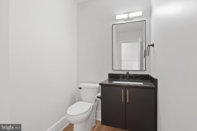 bathroom featuring hardwood / wood-style floors, vanity, and toilet