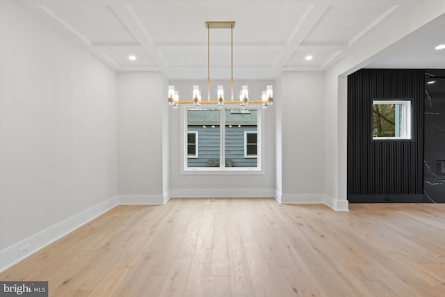 unfurnished dining area featuring beamed ceiling, light hardwood / wood-style floors, coffered ceiling, and a notable chandelier