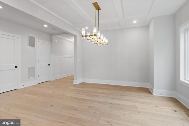 unfurnished dining area featuring beam ceiling, light hardwood / wood-style floors, and a notable chandelier