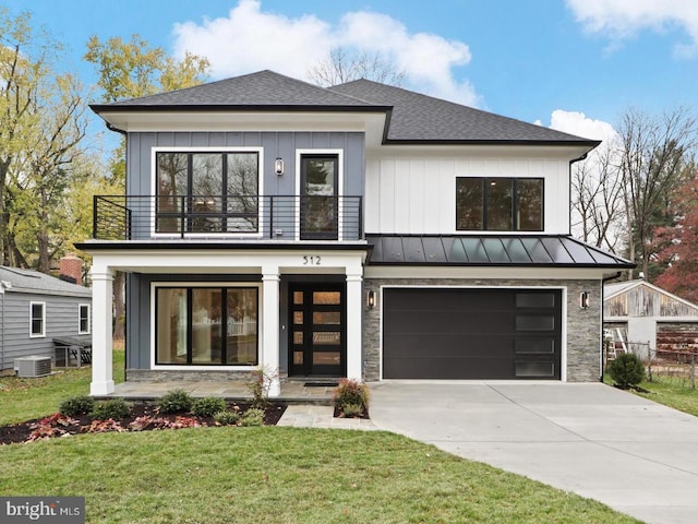 view of front facade featuring central AC unit, a garage, a balcony, and a front lawn