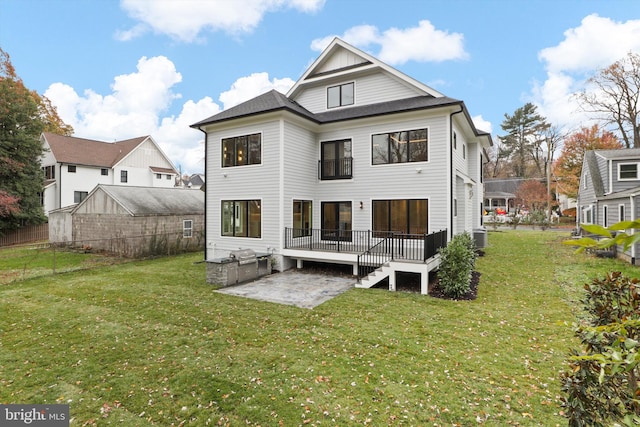 rear view of property featuring a wooden deck, a yard, cooling unit, and a patio