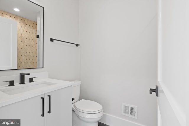 bathroom featuring a shower, vanity, and toilet