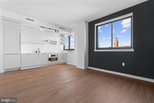 unfurnished living room featuring light hardwood / wood-style flooring and sink