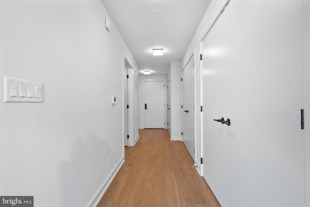 hallway with light hardwood / wood-style floors