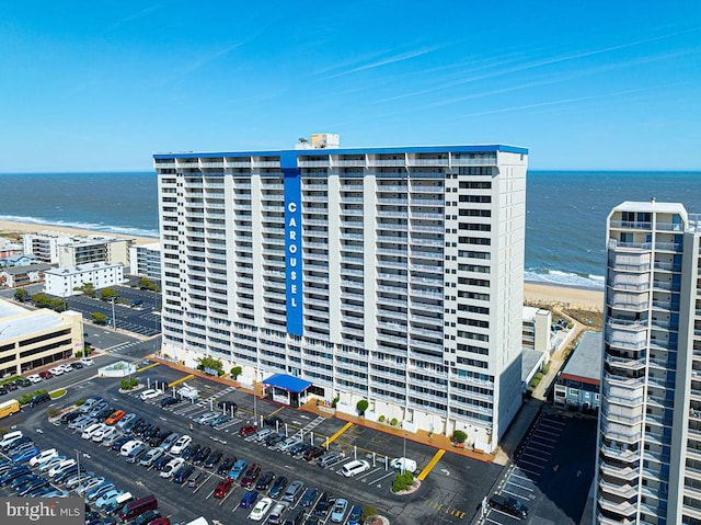 view of building exterior with a water view and a view of the beach