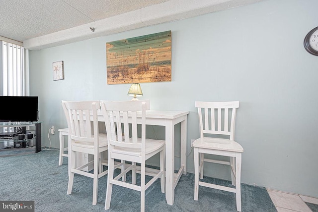 carpeted dining room featuring a textured ceiling