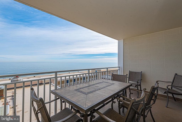 balcony featuring a view of the beach and a water view