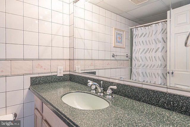 bathroom featuring decorative backsplash, a shower with curtain, vanity, and tile walls