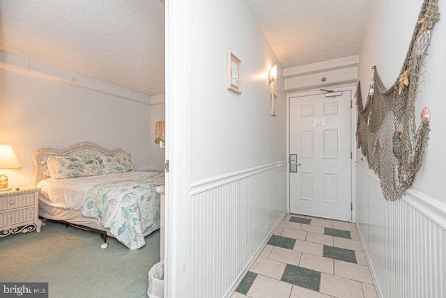 bedroom with a textured ceiling and light carpet