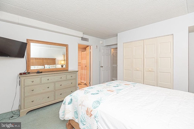 bedroom with light colored carpet, a textured ceiling, connected bathroom, and a closet