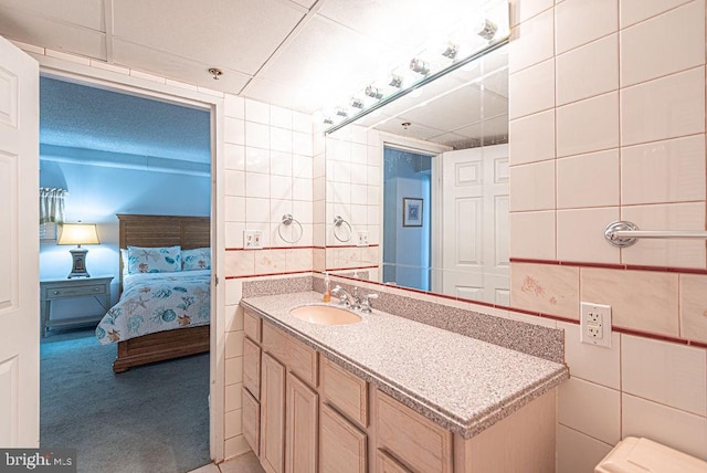 bathroom with vanity and tile walls