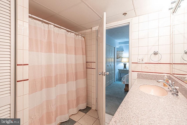 bathroom featuring tile patterned floors, sink, and tile walls