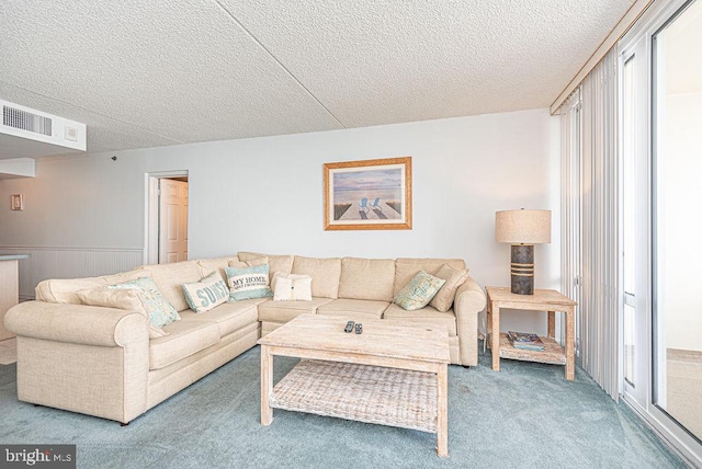 carpeted living room featuring wood walls and a textured ceiling