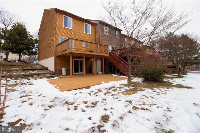 snow covered back of property featuring a deck and central air condition unit