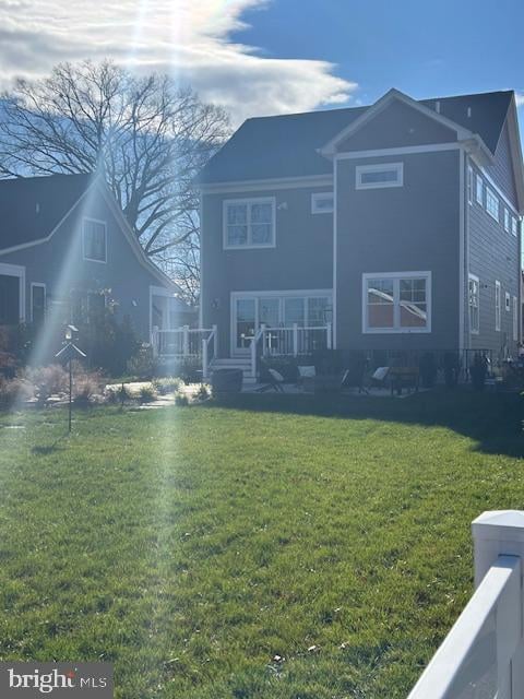 rear view of house featuring a lawn