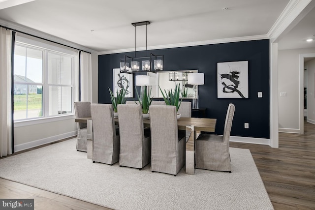 dining room featuring hardwood / wood-style flooring, an inviting chandelier, and ornamental molding