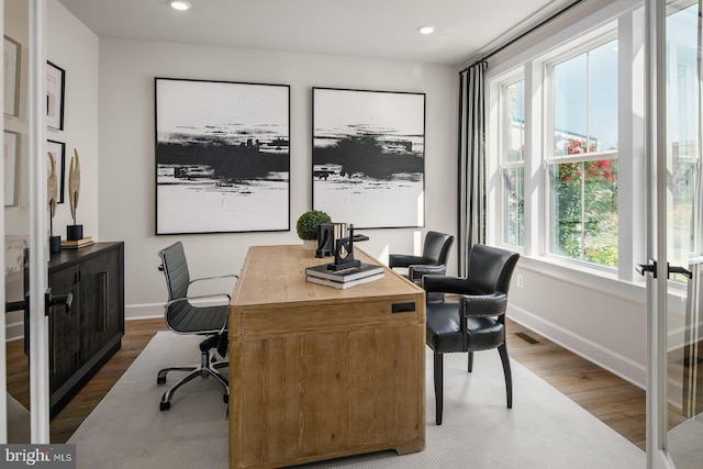 office with a wealth of natural light and dark hardwood / wood-style floors