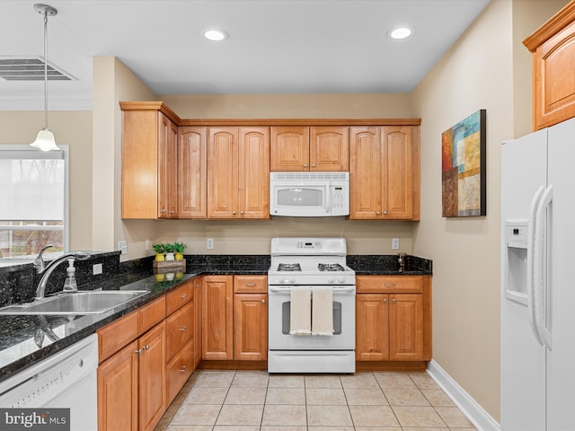 kitchen featuring white appliances, sink, light tile patterned floors, decorative light fixtures, and dark stone countertops