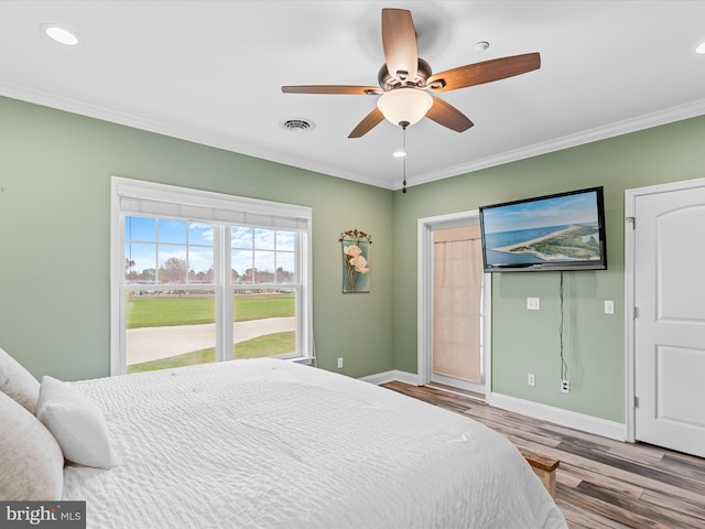 bedroom featuring ceiling fan, light hardwood / wood-style floors, and ornamental molding