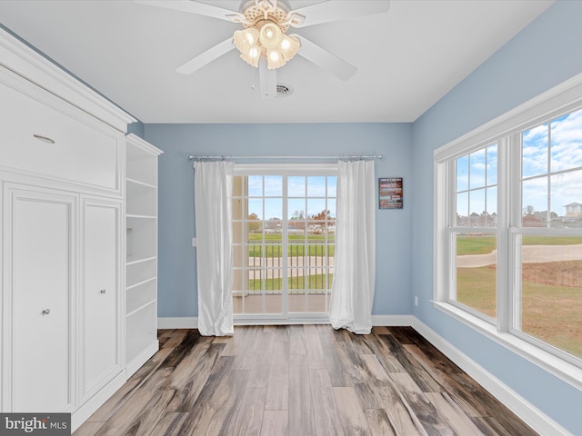 unfurnished dining area featuring ceiling fan and hardwood / wood-style floors