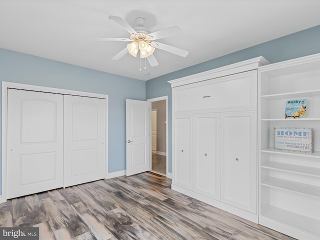 unfurnished bedroom with hardwood / wood-style floors, ceiling fan, and a closet