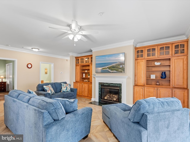 living room featuring ceiling fan, crown molding, and a high end fireplace