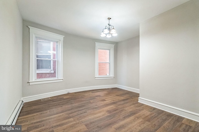 unfurnished room featuring dark hardwood / wood-style flooring, a chandelier, and a baseboard heating unit