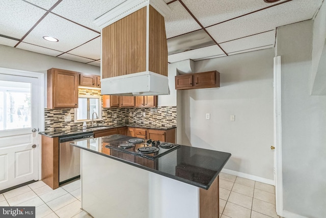 kitchen featuring stainless steel dishwasher, a drop ceiling, a kitchen island, and stovetop