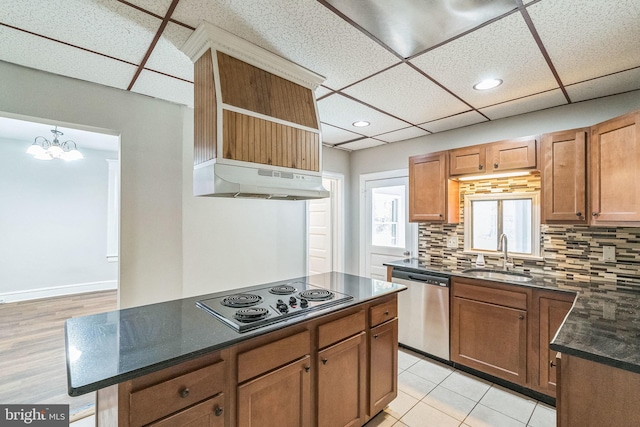 kitchen featuring a paneled ceiling, sink, light wood-type flooring, stainless steel appliances, and a chandelier