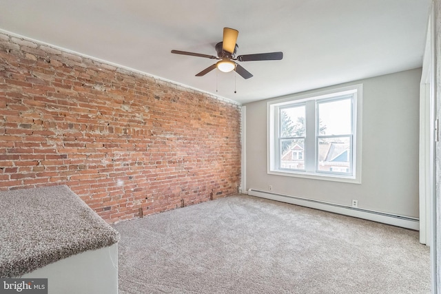 carpeted spare room with baseboard heating, ceiling fan, and brick wall