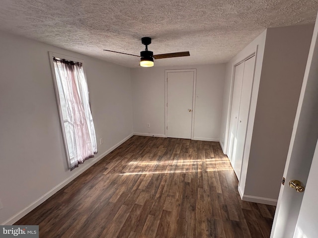 unfurnished bedroom with ceiling fan, dark hardwood / wood-style flooring, and a textured ceiling