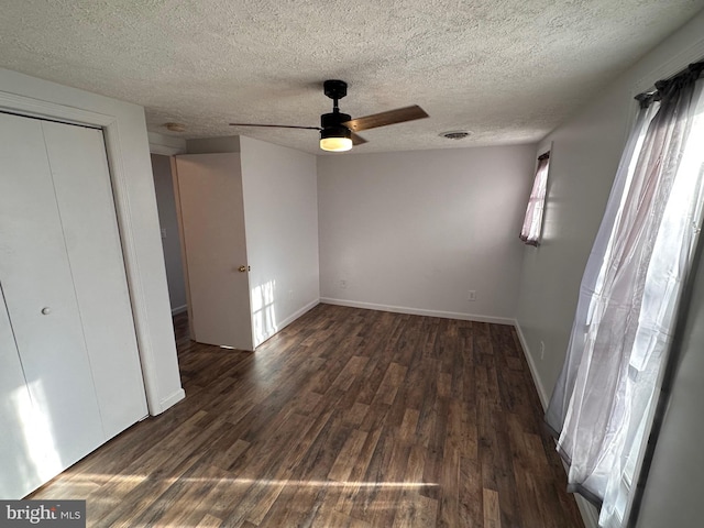 unfurnished bedroom with a closet, ceiling fan, dark hardwood / wood-style flooring, and a textured ceiling