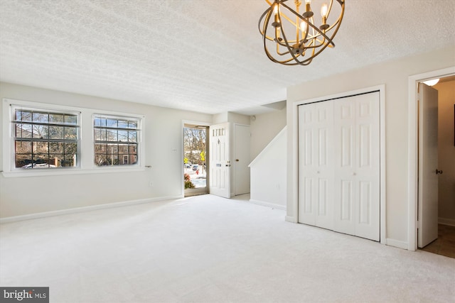 interior space featuring a textured ceiling and light colored carpet