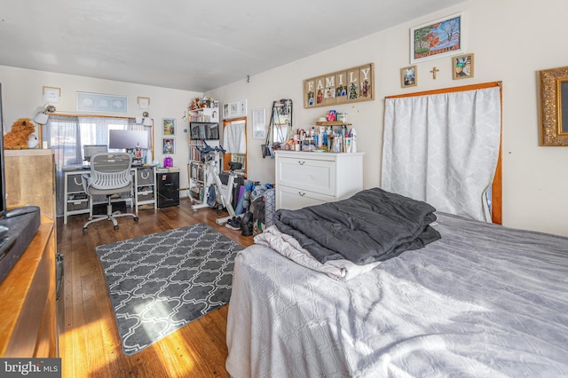 bedroom with dark hardwood / wood-style floors