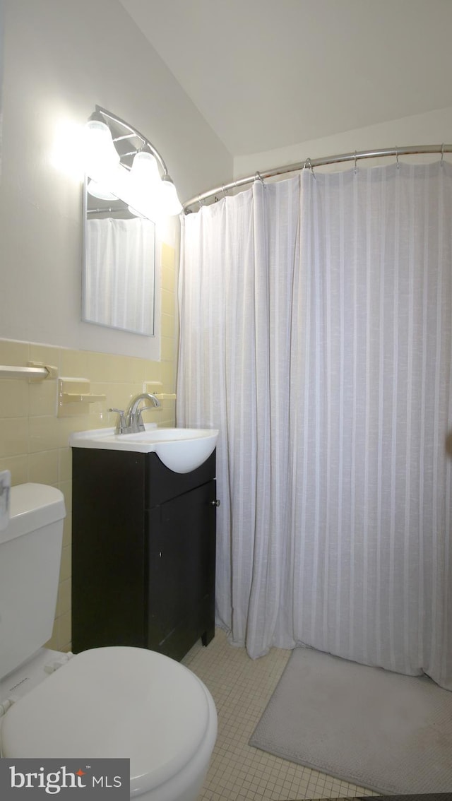 bathroom featuring tile patterned flooring, toilet, vanity, tile walls, and a shower with shower curtain