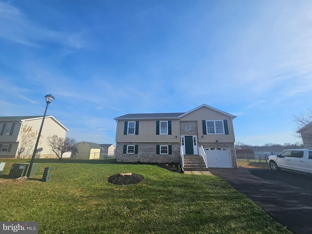 bi-level home with a garage and a front yard