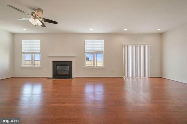 unfurnished living room featuring ceiling fan, plenty of natural light, and light hardwood / wood-style floors