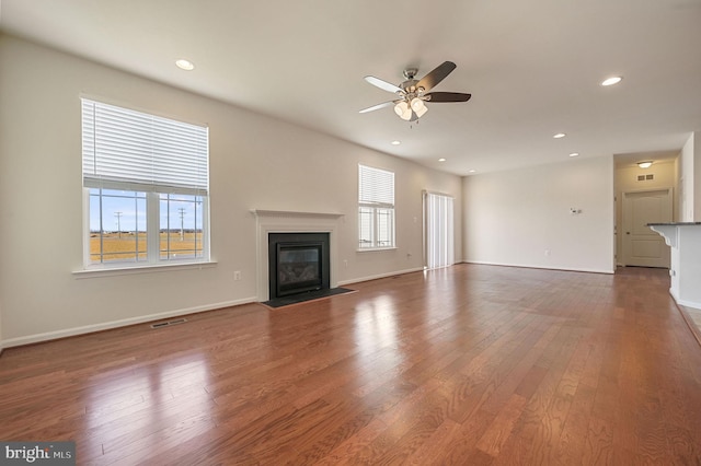 unfurnished living room with dark wood-type flooring and ceiling fan