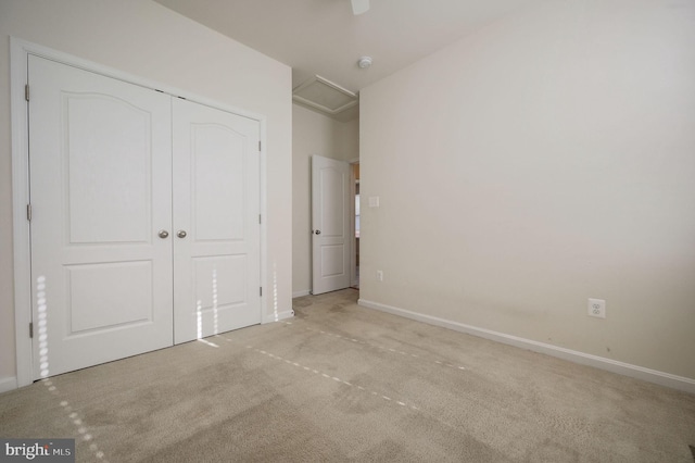 unfurnished bedroom featuring light carpet and a closet